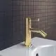 Bidetarmatur in brushed gold von Ideal Standard, mit seitlichem Hebel und einem abgewinkelten Auslauf. Montiert auf einer weißen Oberfläche vor einem gefliesten Hintergrund.